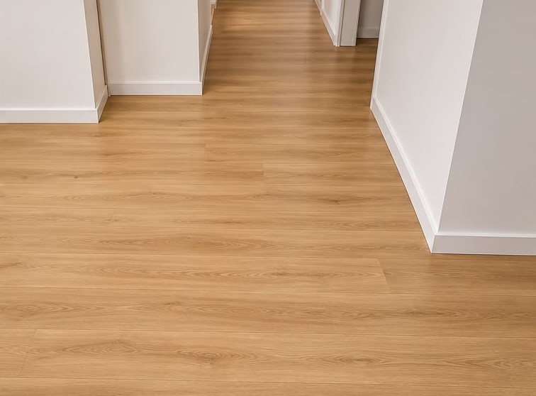 Couloir rénové avec revêtement de sol aspect bois et plinthes blanches – DFE RENOV